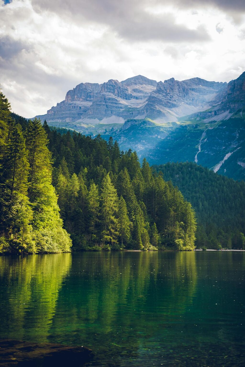 Bergsee mit umliegendem Wald und Bergpanorama