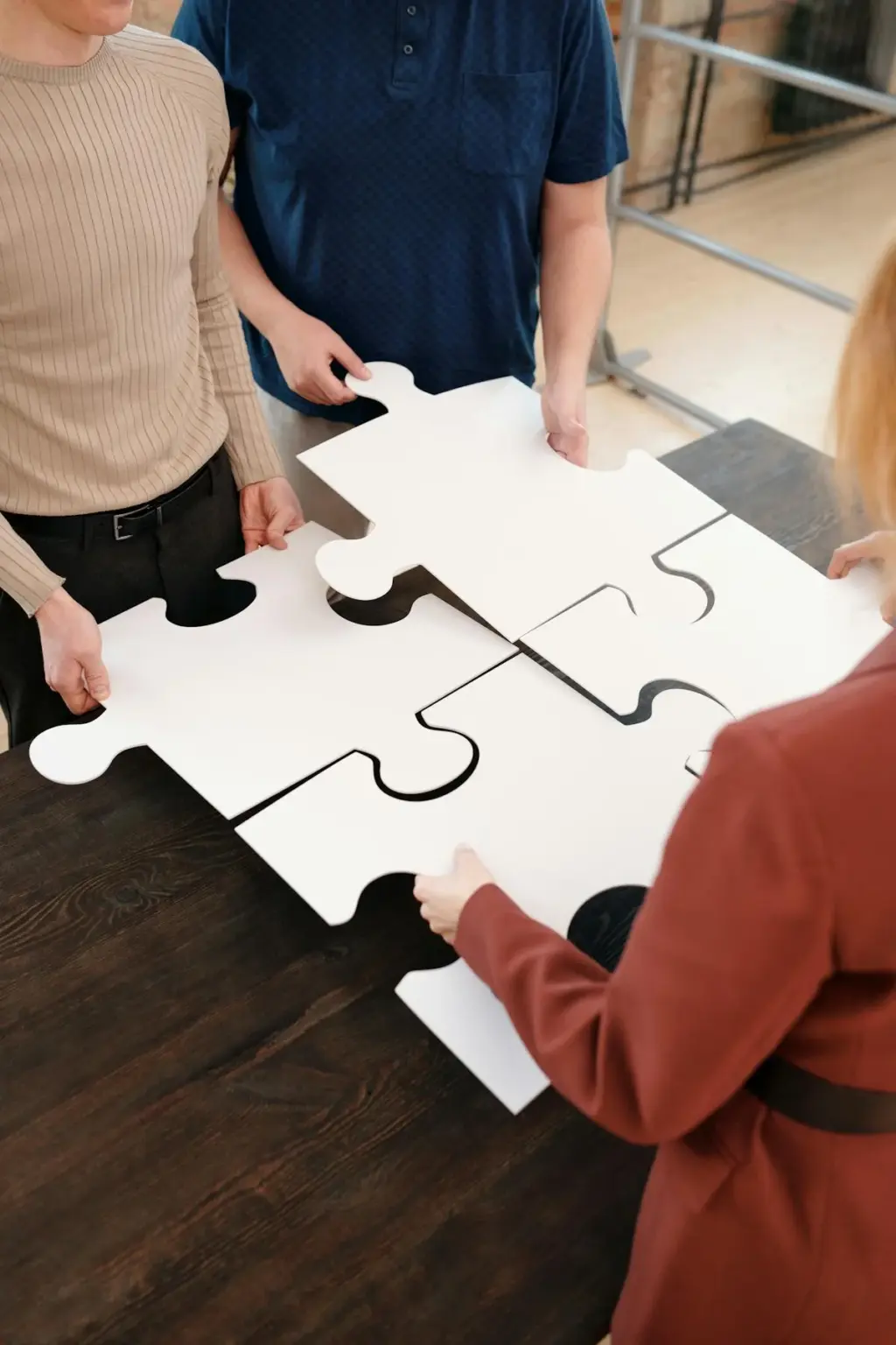 Menschen setzen großes Puzzle gemeinsam zusammen